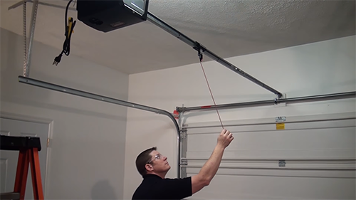 MAN DISENGAGING THE GARAGE DOOR OPENER